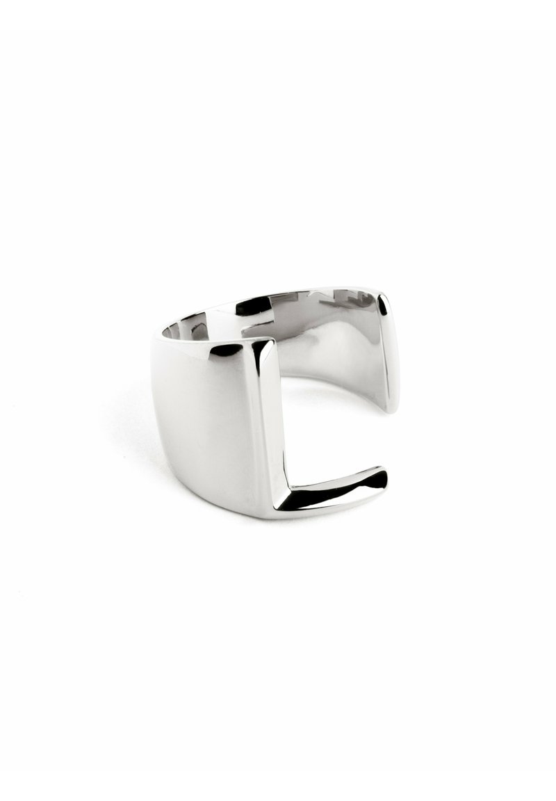 Anello in metallo argentato con superficie liscia e lucida, caratterizzato da un design geometrico aperto e dettagli a taglio angolare.