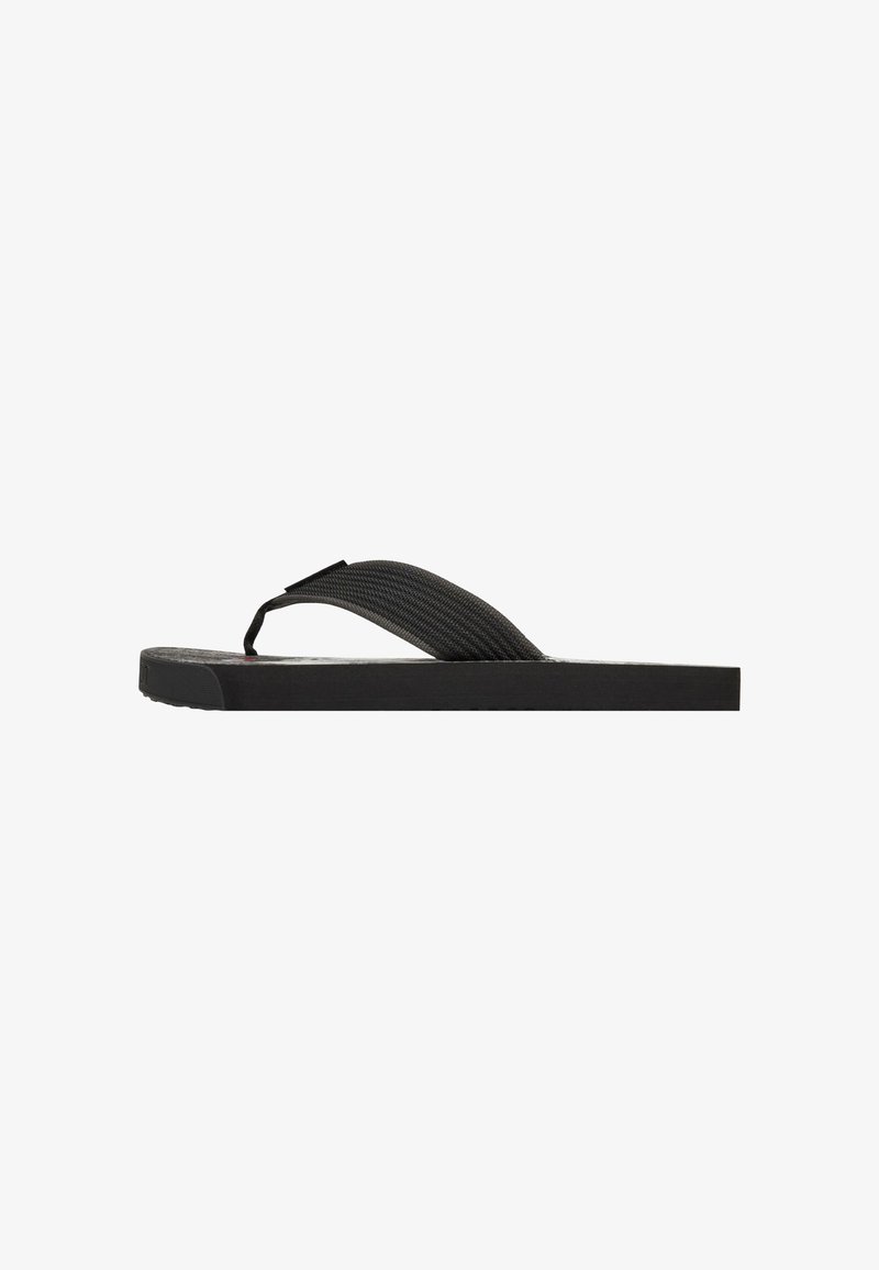 Flip-flop negro con suela de goma plana, tira de tela texturizada y un diseño minimalista sin patrones ni acentos visibles.