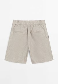 Jasno beżowe szorty w paski, z elastycznym pasem i dwiema tylnymi kieszeniami. Materiał wydaje się teksturowany i przewiewny.