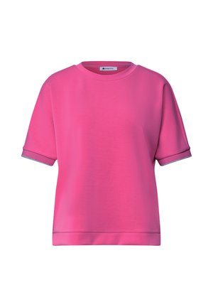 Lyserød kortærmet rundhals-shirt med opsmøgede ærmer og et lille mærke inde i kraven.