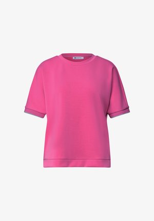 Lyserød kortærmet rundhals-shirt med opsmøgede ærmer og et lille mærke inde i kraven.