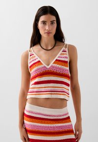 Dzianinowy top w stylu crop z dekoltem w kształcie litery V, zdobiony wielokolorowymi paskami w odcieniach pomarańczu, różu i kremu. Regulowane ramiączka, teksturowany wzór.
