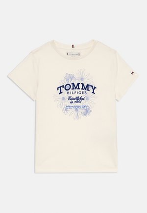 Krémové tričko s krátkým rukávem s modrým květinovým vzorem a textem "Tommy Hilfiger Established in 1985" na přední straně, malé logo na levém rukávu.
