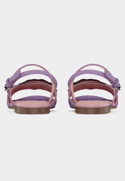 Μωβ σανδάλια με λείο φινίρισμα, που διαθέτουν ρυθμιζόμενα λουριά στον αστράγαλο και ροζ μαλακό πάτο. Η σόλα είναι καφέ και επίπεδη.