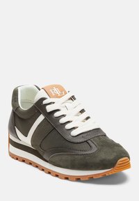 Gröna mocka- och textilsneakers med vita accenter, rund tå, vita snören, och orange logotyp på tungan. Brun gummisula.
