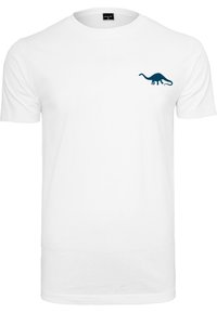 Valkoinen puuvillapaita, jossa on pieni tummansininen dinosauruksen graafinen kuva vasemmassa rinnassa. Klassinen pyöreä kaula-aukko, lyhyet hihat, normaali istuvuus.