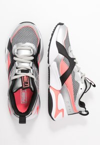 Sneaker atletici argento con accenti neri e rosa e dettagli in rete. Presentano una suola imbottita e un design con lacci.