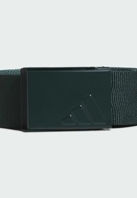 Zeleni tkanjasti pojas s pravokutnom crnom metalnom kopčom koja ima uzdignuti geometrijski uzorak. Teksturna tkanina, jednostavan dizajn, funkcionalno zatvaranje.