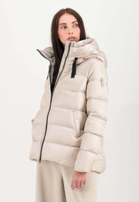 Gepolsterte Pufferjacke in Hellbeige mit hohem Kragen, Frontreißverschluss und schwarzen Hardware-Akzenten. Glatte Textur mit gesteppten Abschnitten.