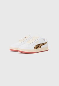 Sneakers bianchi con pannello laterale in stampa leopardata testurizzata, lacci crema e dettagli rossi sulla suola. Materiale liscio con dettagli perforati.