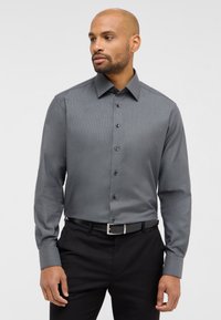 Langærmet, slim-fit, mønstret skjorte i mørkegrå, med spredt krave og sorte knapper, parret med sorte bukser og et bælte.