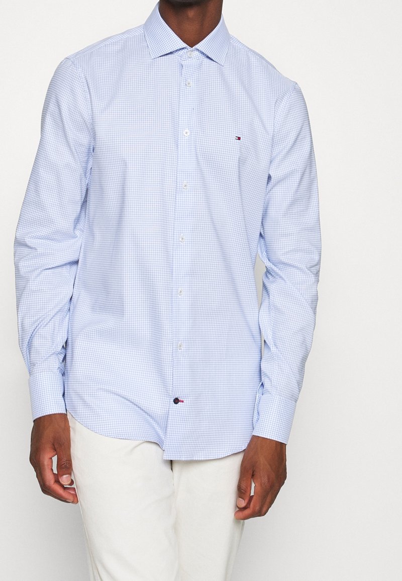 Blau kariertes Langarmhemd mit Button-Down-Kragen. Verfügt über weiße Knöpfe und ein kleines Logo auf der Brust. Hergestellt aus leichtem Stoff.