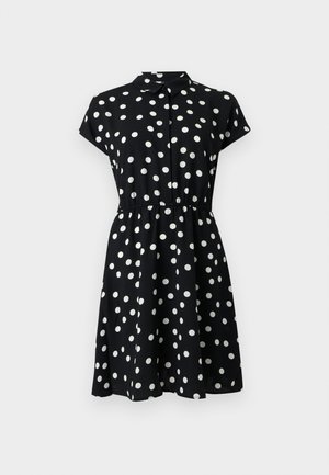 Μαύρο φόρεμα με κοντά μανίκια, λευκές πουά λεπτομέρειες, γιακά στο λαιμό και ζωνάκι στη μέση, που τελειώνει πάνω από τα γόνατα.