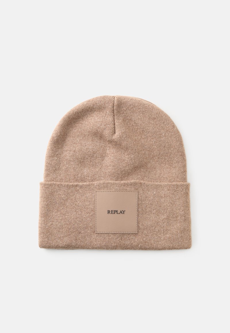 Strikket beanie i lys brun med en foldet skygge og et rektangulært lædermærke mærket "REPLAY." Blød tekstur og enkelt design.