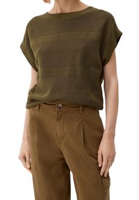 Olive green knit top with a ribbed neckline, featuring horizontal textured stripes. Paired with brown pleated trousers.