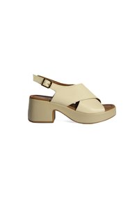 Beige leather slingback sandal with a block heel, featuring a crisscross upper design and a buckle accent on the ankle strap.