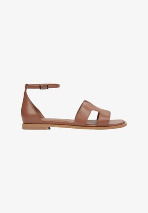 Braune Lederflachsandalen mit einem seitlichen Knöchelriemen, offenem Zehendesign und zwei breiten Vorderriemen, die eine glatte Textur und einen minimalistischen Stil aufweisen.