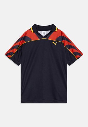 Tengerészeti sportmez piros és sárga kiegészítőkkel, V-nyakkal, rövid ujjakkal, és a Puma logóval a bal felső részen.
