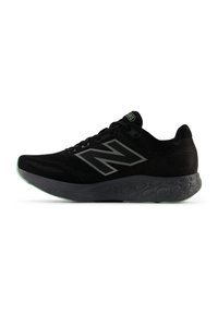 Zwarte New Balance hardloopschoen met mesh bovenwerk, groot "N"-logo, gemusterde tussenzool en groene accenten op de zool en het label van de tong.