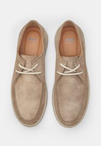 Zapatos de ante beige con un acabado suave, que cuentan con cordones color crema y una punta redonda. La suela tiene textura para mayor agarre y durabilidad.