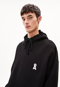 Felpa nera con cappuccio e cordino, caratterizzata da un piccolo logo bianco ricamato sul petto. Tessuto morbido e vestibilità comoda.