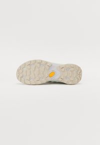 Semelle Vibram avec un motif texturé, couleur beige clair et accents en caoutchouc. Comprend des crampons multidirectionnels pour une traction optimale.