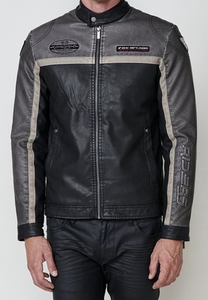 Veste de moto en cuir noir et gris avec des rayures beige, fermeture éclair à l’avant, texte ""RIDERS"" sur la manche et deux écussons sur la poitrine.