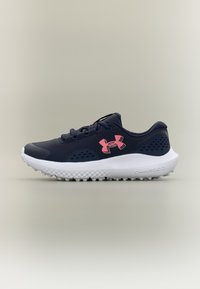 Δρομικό παπούτσι Under Armour σε ναυτικό μπλε χρώμα με ροζ λογότυπο, λευκή επενδεδυμένη σόλα και υφασμένο πέλμα, εμφανισμένο από πλευρά σε ουδέτερο φόντο.