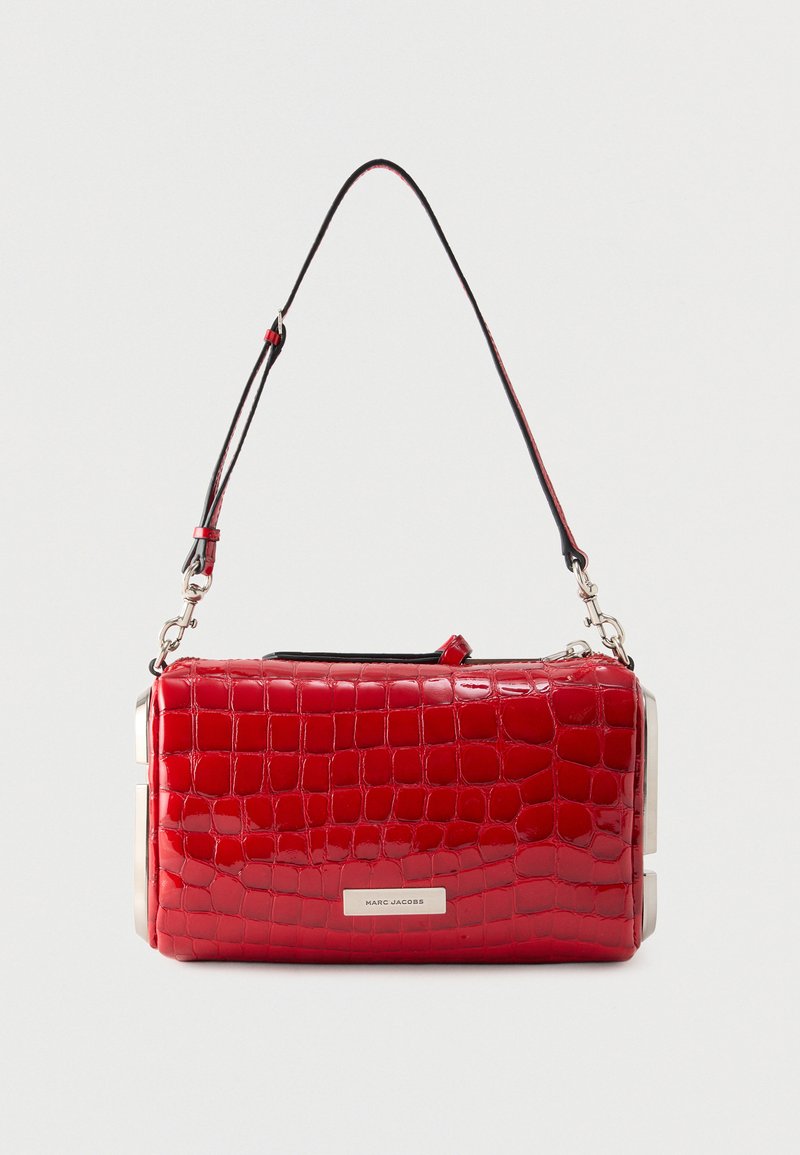 Κόκκινη γυαλιστερή δερμάτινη τσάντα με ανάγλυφη υφή κροκοδείλου, αφαιρούμενο μαύρο ιμάντα και ασημένια μεταλλική πινακίδα, ορθογώνιο σχήμα.