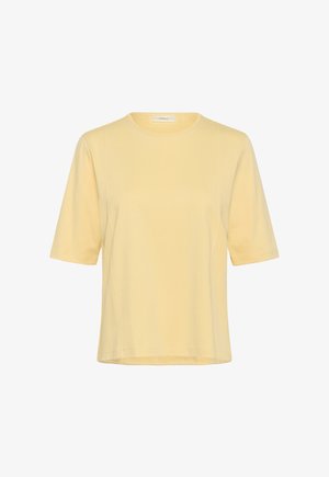 Lühikeste varrukatega, helekollane ümar kaelusega särk, millel on lõdvestunud lõige ja esiküljel ning varrukatel nähtavad õmblused.