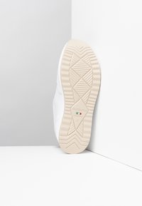 Hvide sneakers med glat læderoverdel, beige gummisål med diamantmønster og prget brandlogo på sålen. Størrelse 37.