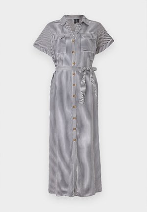 Raidallinen, napitettava mekko tummansiniseksi ja valkoiseksi, jossa on lyhyet hihat, vyöllinen vyötärö ja kaksi rintataskua. Kuviollinen kangas, jossa on pehmeä tekstuuri.