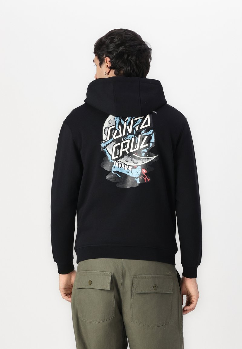 Felpa nera con cappuccio caratterizzata da un design grafico con il testo "SANTA CRUZ" e un'illustrazione di uno squalo. Tessuto morbido con una vestibilità comoda.
