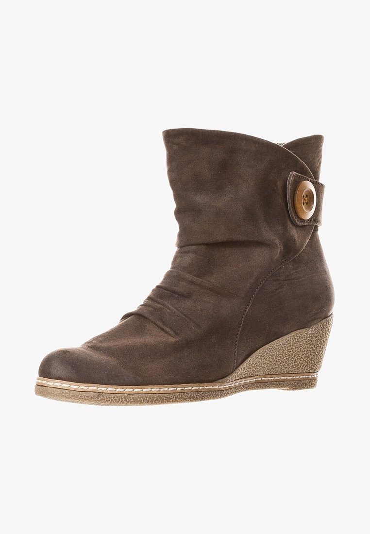 Bottine en daim marron avec talon compensé, bout plié, détail à bouton sur le côté et semelle texturée.