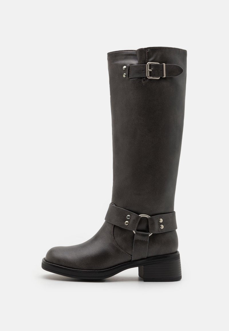 Botte haute en cuir marron foncé avec talon bas, bride décorative à la cheville avec anneau en métal et boucle réglable près du haut.