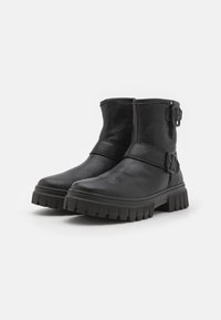 Sorte skinn ankelstøvler med rund tå, sidebelter og en tykk, riller gummi såle. Glatt tekstur og minimalistisk design.