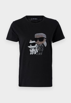Tricou negru din bumbac cu un grafic din strassuri reprezentând o persoană și o pisică albă, ambele purtând ochelari de soare. Guler rotund și mâneci scurte.