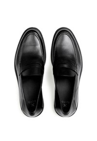 Mocassins en cuir noir avec une finition lisse, un bout arrondi et un motif cousu sur le dessus du pied. Doublure intérieure texturée visible.