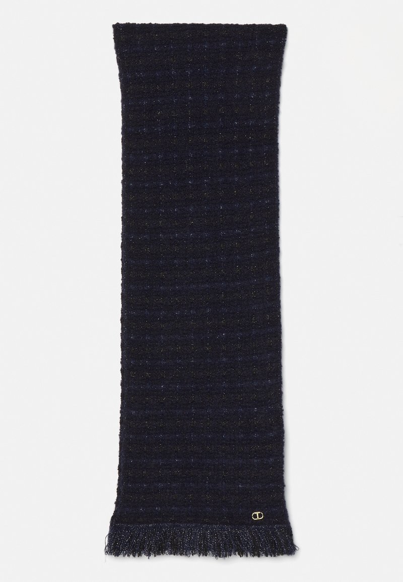 Écharpe en tricot bleu marine foncé texturé avec un subtil scintillement, extrémités à franges et un petit logo doré près d'une frange.
