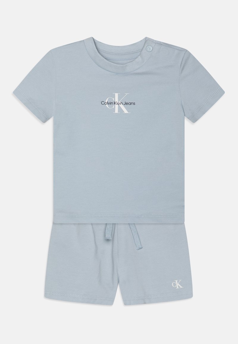 Light blue cotton short-sleeve t-shirt with a crew neck and button detail. Paired with matching shorts featuring an elastic waistband and logo.