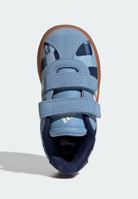 Blå barnsneaker med övre i mocka och nät, med ett rutigt mönster och två kardborreband. Gummisulor i brunt.