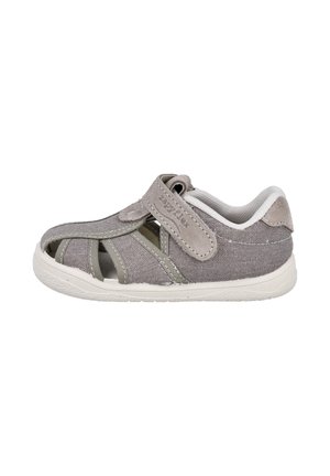 Sandalia gris para niños de punta cerrada con correa ajustable de Velcro y interior acolchado blanco, mostrada de lado sobre un fondo blanco.