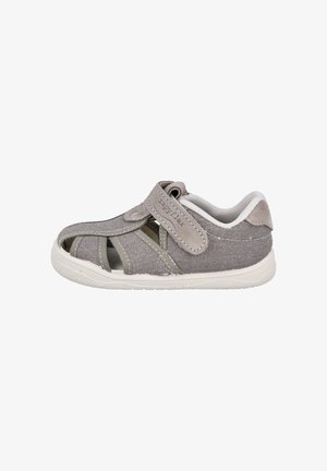 Sandalia gris para niños de punta cerrada con correa ajustable de Velcro y interior acolchado blanco, mostrada de lado sobre un fondo blanco.