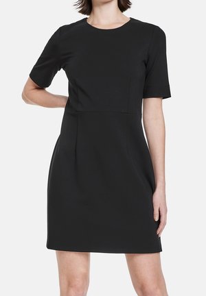 Robe noire à manches courtes avec un col rond, corsage ajusté, jupe plissée et texture lisse. Design simple, sans motifs ni accents visibles.