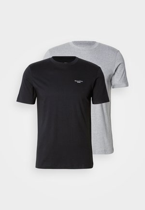 Dvě trička v balení, jedno černé a druhé světle šedé. Obě mají krátké rukávy, kulatý výstřih, jsou vyrobené z bavlny a mají minimální branding.