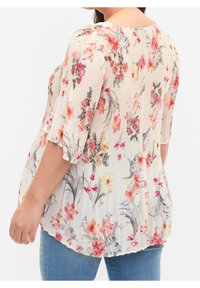 Blusa floreale in tessuto leggero e plissettato. Sfondi crema con vivaci motivi floreali rosa, giallo e verde. Vestibilità rilassata con maniche a 3/4.