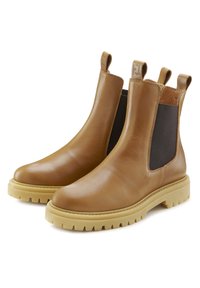 Bruine leren Chelsea boots met elastische zijkanten, aantrektabs en een stevige rubberen zool. Lichtbeige zool met een gestructureerd profiel.