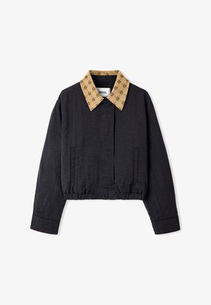 Kurze Jacke aus schwarzem Stoff, mit einem gemusterten beigen Kragen. Verfügt über eine Frontleiste und seitliche Taschen mit einem gerafften Saum.