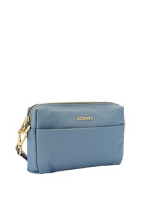 Blue nylon bag with gold hardware, zip closure, and front pocket. Features embossed brand name. Rectangle shape with sleek design.