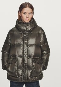 Olive green puffer jacket featuring a high collar, diagonal quilted pattern, two front pockets, and a glossy finish.